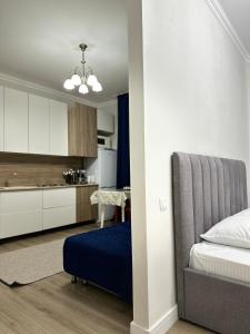 een slaapkamer met een bed en een keuken bij Apartment Korkem 1 at Left Coast in Astana in Astana