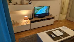 a living room with a flat screen tv on a white entertainment center at Guest House Mikeli (BESPL. DORUCAK)-(FREE BREAKFAST) in Podgorica