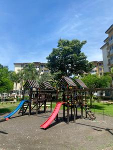 un parque con parque infantil con toboganes de colores y una estructura de juegos en Costa Linda walking distance to the beach, en Jacó