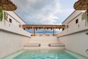 une piscine au milieu d'un bâtiment dans l'établissement Nãmas Tulum, à Tulum