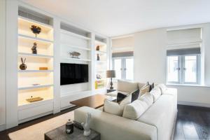 sala de estar con sofá y TV en Prime Mayfair Pied De Terre Sleeps 6 Top Floor en Londres