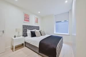 Habitación blanca con cama y ventana en Prime Mayfair Pied De Terre Sleeps 6 Top Floor en Londres