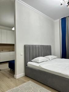 een slaapkamer met een bed met een grijs hoofdeinde bij Apartment Korkem 1 at Left Coast in Astana in Astana