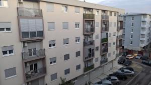 an apartment building with cars parked in a parking lot at Guest House Mikeli (BESPL. DORUCAK)-(FREE BREAKFAST) in Podgorica