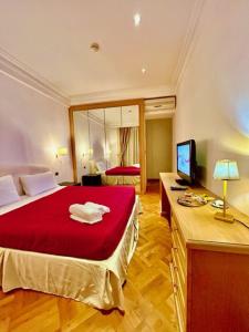 1 dormitorio con cama roja y escritorio con TV en Auditorium Maxxi luxury suite Roma en Roma