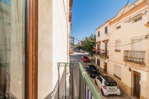 vistas a una calle con coches aparcados en el balcón en La Casa Vella EL BEDORC, en Piera