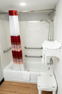 a bathroom with a red and white shower curtain at Red Roof Inn Rochester - Henrietta in Henrietta