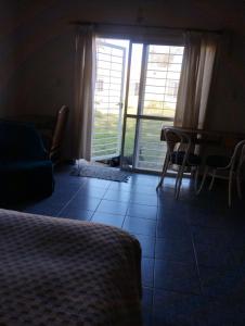 um quarto com uma cama, uma mesa e uma janela em El naranjo em Mendoza