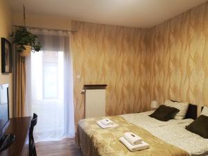 - une chambre avec un lit et 2 serviettes dans l'établissement Apartament Willa Port "Kaczorek", à Ostróda