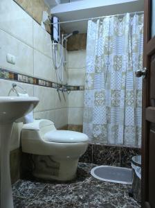 een badkamer met een toilet, een wastafel en een douche bij Encantadora habitación en Breña in Lima