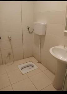 a white bathroom with a toilet and a sink at سلسبيل للغرف المفروشة in Al Khobar
