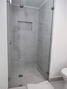 een douche met een glazen deur in de badkamer bij Habitación sencilla con baño privado Unicentro in Bogota