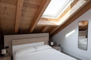 - une chambre avec un lit blanc et une lucarne dans l'établissement Affittacamere Bar Leo, à Pregnana Milanese