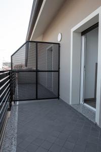 - un balcon avec une porte noire dans un bâtiment dans l'établissement Affittacamere Bar Leo, à Pregnana Milanese