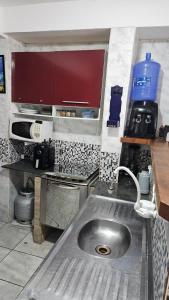 uma cozinha com um lavatório de aço inoxidável em Casa Will Maresias em Maresias