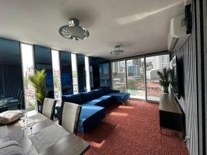 a living room with a blue couch and some windows at 7a in Panama City