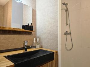 a bathroom with a black sink and a shower at Octave par Madame Conciergerie in Bruz