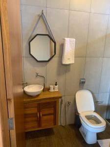 a bathroom with a toilet and a sink and a mirror at pousada solar da canastra in Delfinópolis +79 photos