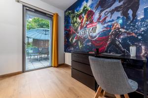 a home office with a superhero mural on the wall at Planète Erevan - 10min from DisneyLand, Free Parking, Self-Checkin in Montévrain