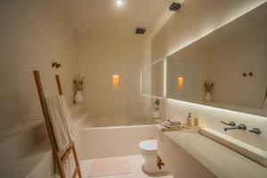 a bathroom with a tub and a toilet and a sink at Nãmas Tulum in Tulum