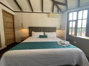 a bedroom with a large bed with a green blanket at Hosteria Punta Blanca in Punta Blanca