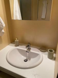 La salle de bains est pourvue d'un lavabo blanc et d'un miroir. dans l'établissement Einliegerwohnung am Wald, à Forbach