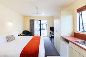um quarto de hotel com uma cama grande e uma cozinha em Bella Vista Motel Palmerston North em Palmerston North