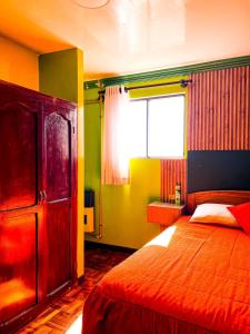 um quarto com uma cama grande e uma janela em HOSTAL SAN MARCOS POTOSÍ em Potosí