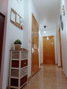 un pasillo con una puerta y un tocador con una planta en Villa Rosario en San Fulgencio