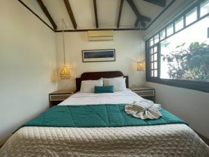 a bedroom with a bed with a green blanket and a window at Hosteria Punta Blanca in Punta Blanca