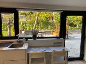 a kitchen with a table and chairs and a window at Baiona Valley Hideaway Near Beach in Baiona