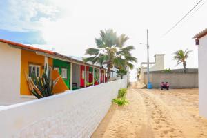 a dirt road next to a row of houses at Pousada Brisa do Mar in Galinhos