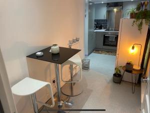 a kitchen with a small table and a refrigerator at Central Private Double Bedroom in a 2bedroom Apartment, connected via underground, overground and many bus routes in London