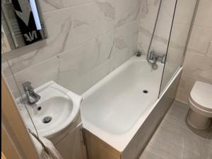 Un baño con lavabo, bañera e inodoro. en Central 1bedroom Apartment, connected via underground, overground and many bus routes, en Londres