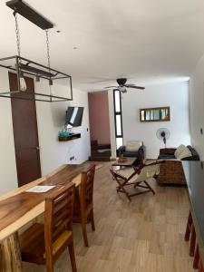uma sala de estar com uma mesa de madeira e cadeiras em Telchac Villa de 3 pisos con club playa em Telchac Puerto