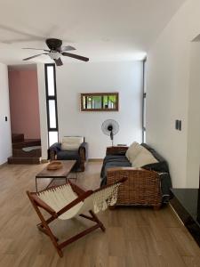 uma sala de estar com um sofá e uma cadeira em Telchac Villa de 3 pisos con club playa em Telchac Puerto