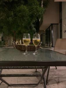 dois copos de vinho branco sentados numa mesa em Telchac Villa de 3 pisos con club playa em Telchac Puerto