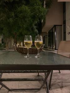 two glasses of white wine sitting on a table at Telchac Villa de 3 pisos con club playa in Telchac Puerto