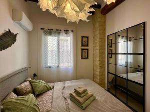a bedroom with a large bed with a chandelier at VillaVieja17 Studio-Apartments in Alicante