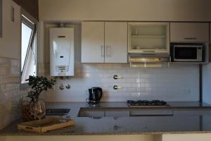 a kitchen with white cabinets and a counter top at Las Marias 21 in San Salvador de Jujuy