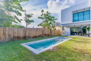 a backyard with a swimming pool and a fence at Paradise House w Pool & Yard in Miami