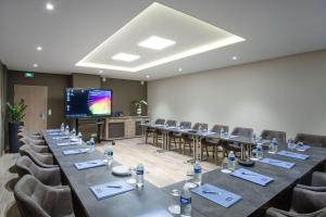 a conference room with tables and chairs and a projection screen at Kyriad Chambéry Centre - Hôtel et Résidence in Chambéry