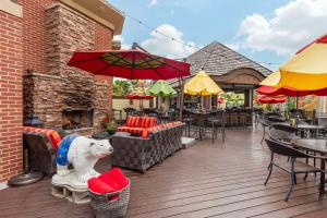 eine Terrasse mit einer weißen Hundestatue auf einem Stuhl in der Unterkunft Best Western Plus White Bear Country Inn in White Bear Lake