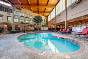 a pool in the courtyard of a hotel with tables and chairs at Best Western Plus White Bear Country Inn in White Bear Lake