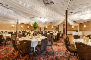 Best Western Plus White Bear Country Inn في White Bear Lake: قاعة احتفالات مع طاولات وكراسي في غرفة