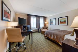 a hotel room with a bed and a desk with a computer at Best Western Plus White Bear Country Inn in White Bear Lake