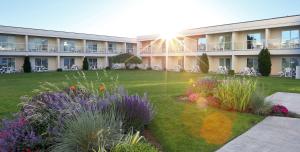 a building with a garden with flowers in the yard at Best Western Plus Kelowna Hotel & Suites in Kelowna