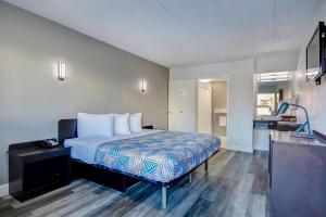 ein Hotelzimmer mit einem Bett und einem Bad in der Unterkunft Motel 6 Columbus OH - OSU North in Columbus