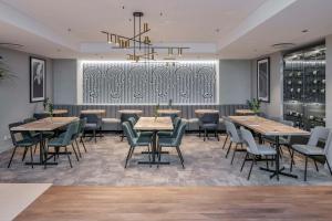 a restaurant with tables and chairs and a chandelier at Radisson Hotel Kaunas in Kaunas