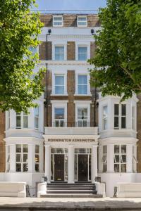 - un grand bâtiment blanc avec un panneau dans l'établissement Mornington Hotel London Kensington, BW Premier Collection, à Londres
